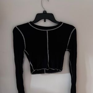 A cropped black with outside stitching top. Super trendy and cute. Size small.